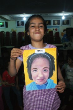 Afghanistani orphan holding a portrait made for her by Katherine Choi.