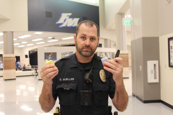 School Resource Officer Derek Mueller stands in the main hallway, displaying the various vapes he has collected from students. Even with the implementation of the new vape policy, students have already been caught committing vape-related offenses. “Just this school year alone, three vapes have been taken off students,” Mueller said.